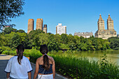 Junge Mädchen beim Besuch des Central Park Lake mit den markanten Gebäuden der Upper West Side im Hintergrund, New York City, USA