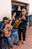 Guitarists playing for tips on the street in the historic center of Quito, Ecuador.