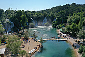 Aerial view of Kravica Waterfall surrounded by lush greenery and tranquil waters, Ljubuski, Bosnia and Herzegovina.