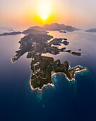 Aerial view of serene sunset over the idyllic island of Meganisi with tranquil coastline and blue sea, Katomeri, Ionian Islands, Greece.