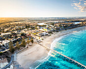 Aerial view of sunrise over the beautiful beach and jetty with blue water and coastline, Port Noarlunga, South Australia, Australia.