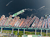 Aerial view of bustling urban activity at the busy shipyard and wharf with boats on the Buriganga River, Subhadya, Keraniganj, Dhaka, Bangladesh.