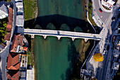 Aerial view of old stone bridge over a river with buildings and green water, Konjic, Bosnia and Herzegovina.