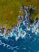 Luftaufnahme der zerklüfteten Klippen und krachenden Wellen entlang der unberührten Küste, Dumha Eige, County Mayo, Irland.