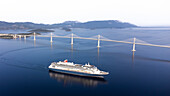 Luftaufnahme der Peljesac-Brücke mit einem darunter vorbeifahrenden Kreuzfahrtschiff über die Adria, Komarna, Kroatien.