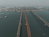Aerial view of bustling cityscape with a prominent bridge over a river and busy harbor, Dhaka, Dhaka, Bangladesh.