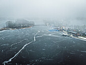 Aerial view of frozen lake with a tranquil village and snow-covered trees, Trakai, Trakai, Lithuania.