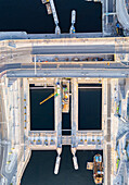 Luftaufnahme der Karl-Johans-Schleuse am Vattentorget mit ihrer verschlungenen Struktur, in der sich das ruhige Wasser unter der Brücke spiegelt, Stockholm, Stockholms län, Schweden.