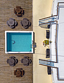 Luftaufnahme eines makellosen blauen Swimmingpools, der in starkem Kontrast zum hölzernen Deck und der streng weißen Struktur steht, Split, Gespanschaft Split-Dalmatien, Kroatien.