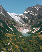 Luftaufnahme des Bøyabreen-Gletschers mit seinem strahlend weißen Eis im Kontrast zu dem üppigen grünen Tal und dem ruhigen blauen See, Fjærland, Vestland, Norwegen.