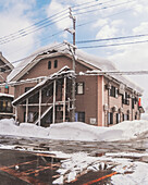 View of snow-laden roof of a building contrasting with the blue sky in the background, creating a serene winter scene, Tsunan, Niigata, Japan.