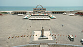 Aerial view of the expansive Black Star Square, framed by the serene ocean and fluttering Ghanaian flags, a scene of national pride, Osu Klottey, Greater Accra Region, Ghana.