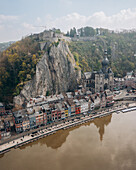 Luftaufnahme der Zitadelle von Dinant auf einer dramatischen Klippe mit Blick auf bunte Gebäude und die Stiftskirche Notre-Dame, Dinant, Région wallonne, Belgien.