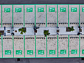 Aerial view of a parking lot featuring green swan symbols contrasting against the muted gray pavement, Berlin, Berlin, Germany.