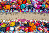 Aerial view of a vibrant majlis public food offering with people in colorful clothing gathered for a communal feast, Sekherkola, Bogura, Rajshahi, Bangladesh.