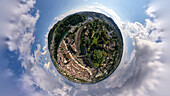 Aerial view of a tiny planet perspective of the historic city center with a river and lush greenery under a cloudy sky, Breite, Schaffhausen, Switzerland.