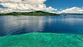 Aerial view of tropical island with reef and clouds over the ocean, Northern, Fiji.