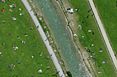 Aerial view of Schwabinger river surrounded by green park with people enjoying leisure activities, Munchen, Bayern, Deutschland.