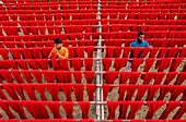 Araihazar, Bangladesh - 04 December 2020: Aerial view of vibrant fabrics dyeing workshop with colorful rows of cloth and workers, Satgram, Araihazar, Dhaka, Bangladesh.