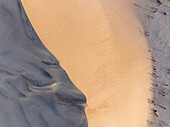 Aerial view of dune 7 with a man standing on the edge during sunset, Erongo, Namibia.