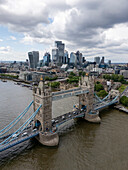 Aerial view of tower bridge over thames river with modern skyline and bustling city life, central london, england, united kingdom.