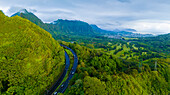 Luftaufnahme von üppig grünen Bergen und ruhigen Tälern mit einer kurvenreichen Straße, Kailua, Hawaii, Vereinigte Staaten.