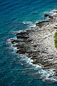 Aerial view of rocky coastline with waves and beautiful blue sea, Pula, Istria, Croatia.