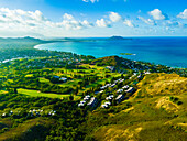 Aerial view of beautiful sandy beach and lush greenery along the coastline with residential areas and hills, Kailua, Hawaii, United States.