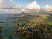 Aerial view of beautiful coastline with tranquil ocean, lush mountain, and picturesque village, Flacq, Mauritius.