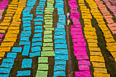 Araihazar, Bangladesh - 04 December 2020: Aerial view of vibrant fabrics dyeing process with colorful textiles arranged in rows, Duptara, Araihazar, Dhaka, Bangladesh.