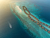 Aerial view of beautiful Muravandhoo Island with luxury bungalows and turquoise waters, Raa Atoll, Maldives.