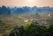 Luftaufnahme einer Aussichtsterrasse auf dem Berggipfel mit Blick auf die Berglandschaft von Guilin bei Sonnenaufgang mit tief hängenden Wolken, Guangxi, China.