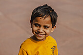 New Delhi, India - 24 June 2025: View of a young boy in a vibrant yellow shirt, his dark hair contrasting with his bright, genuine smile against a muted backdrop.