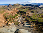 Aerial view of rugged mountains meet barren landscapes, a tapestry of ochre and grey, cut by winding paths of sediment, revealing the earth's raw beauty, Grindavik, Grindavíkurbær, Iceland.