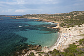 Aerial view of a secluded beach where turquoise waters meet rocky shores and sunbathers relax under the Sardinian sun, Sassari, Sardinia, Italy.
