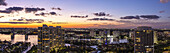 Aerial view of golden lights illuminate the high-rise buildings reflecting in the dark waters under a vibrant sunset sky, Sunny Isles Beach, Florida, United States.