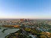 Aerial view of a sprawling metropolis, where skyscrapers pierce the skyline amidst a mosaic of verdant parks and sun-kissed streets, Los Angeles, California, United States.