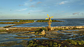 Aerial view of a vintage yellow windmill standing proudly amidst the textured salt flats and tranquil waters, Kralendijk, Bonaire, Caribbean Netherlands.