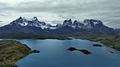Aerial view of turquoise waters mirroring jagged, snow-dusted peaks under a somber sky, a symphony of cold blues and stark whites., Ushuaia, Tierra del Fuego Province, Argentina.
