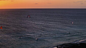 Aerial view of the sun kissing the sea as kitesurfers dance across the waves in a symphony of motion and color, Kralendijk, Bonaire, Caribbean Netherlands.