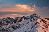Blick auf schneebedeckte Berggipfel, die sich vor einem goldenen Sonnenuntergang in den Himmel schieben, ein heiterer Blick auf die raue Schönheit der Natur, Bialka Tatrzanska, Województwo malopolskie, Polen.