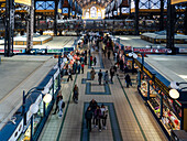 Budapest, Hungary - 07 October 2025: View of the Great Market Hall bustling with shoppers under its high, ornate roof, a vibrant mix of colors and textures creating a lively atmosphere.
