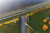 Aerial view of a concrete structure contrasts against the lush green grass, the road, and the shimmering water, capturing the essence of urban tranquility, Tallinn, Harju County, Estonia.