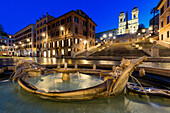 View of the Fontana della Barcaccia fountain sparkles with gentle illumination at the base of the Spanish Steps, Rome, Lazio, Italy.