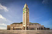 View of the Hassan II Mosque's towering minaret rises majestically against the clear blue sky, its intricate details a testament to Moroccan artistry, Casablanca, Casablanca-Settat, Morocco.