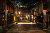 View of dimly lit street with traditional wooden buildings and glowing lanterns creating a warm contrast against the dark night, geisha street, Kanazawa, Ishikawa, Japan.