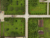 Luftaufnahme von üppigen grünen Rasenflächen und Fußgängerwegen, die sich in der Nähe von DITICH NHADAY BMT kreuzen, eine ruhige Szene von oben, Buon Ma Thuot, Dak Lak, Vietnam.