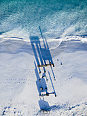 Luftaufnahme des türkisfarbenen Wassers, das auf den unberührten weißen Sand trifft und lange Schatten auf eine Struktur am Strand wirft, Westaustralien, Westaustralien, Australien.
