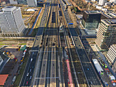 Aerial view of the stark contrast between the modern office buildings and the busy railway lines, Amsterdam, North Holland, Netherlands.