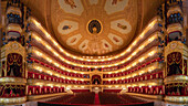 Moskva, Russia - 23 December 2021: View of the opulent interior of the Bolshoi Theatre, with its tiered balconies, plush red seating, and ornate gold detailing, creating a captivating spectacle.